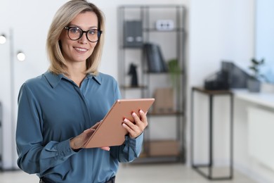 Photo of Portrait of businesswoman using tablet in office, space for text