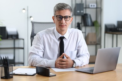 Portrait of businessman at table in office