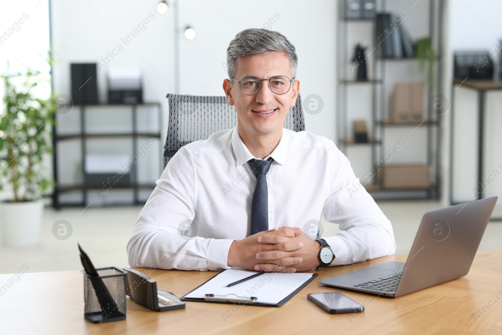 Photo of Portrait of businessman at table in office