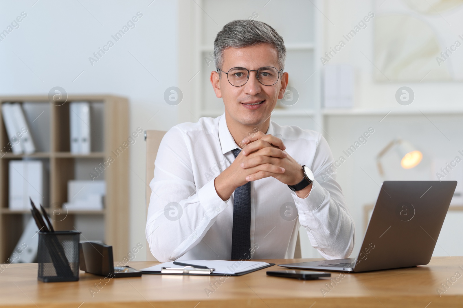 Photo of Portrait of businessman at table in office