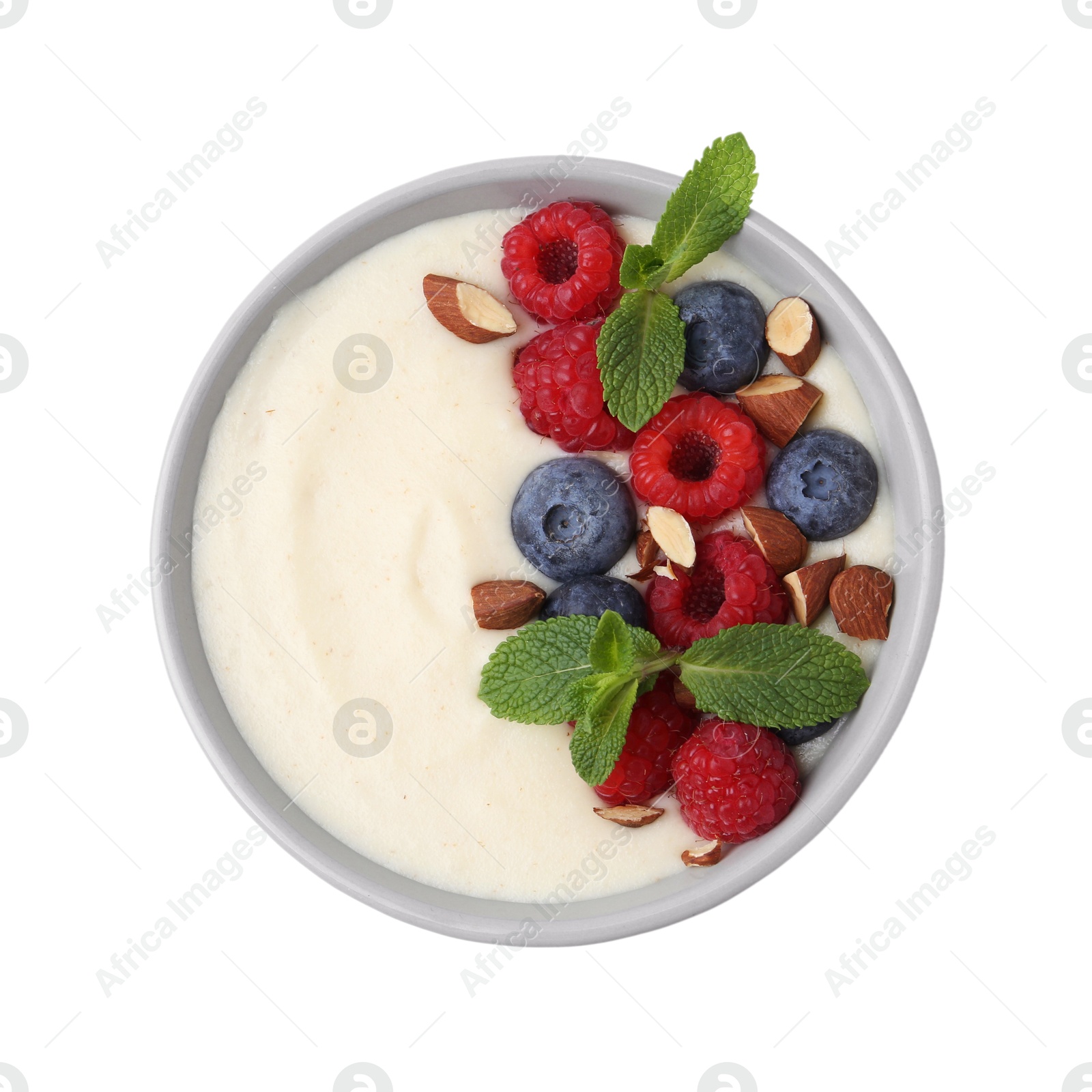 Photo of Tasty cooked semolina porridge with almonds, berries and mint isolated on white, top view