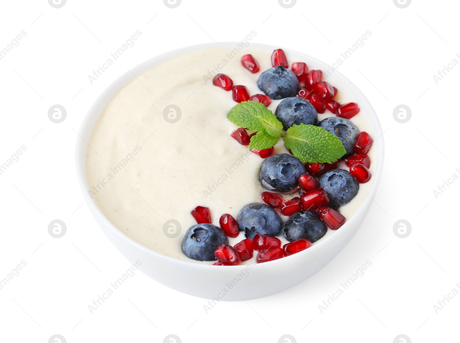 Photo of Tasty cooked semolina porridge with blueberries, pomegranate and mint isolated on white