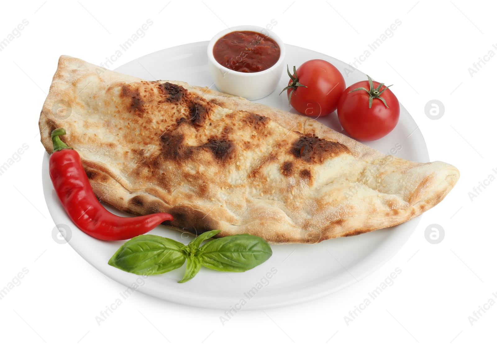 Photo of Delicious calzone with ketchup, fresh tomatoes and chili pepper isolated on white