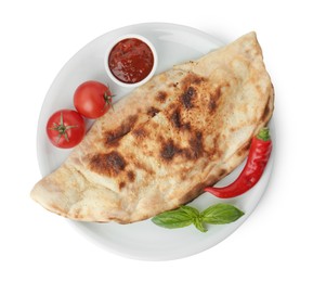 Photo of Delicious calzone with ketchup, fresh tomatoes and chili pepper isolated on white, top view