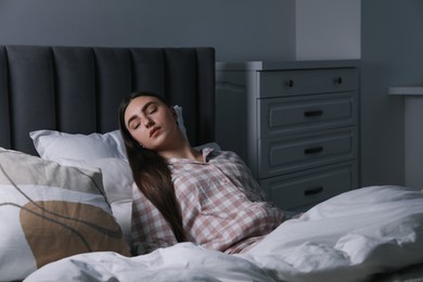 Photo of Young woman suffering from sleepwalking on bed at home