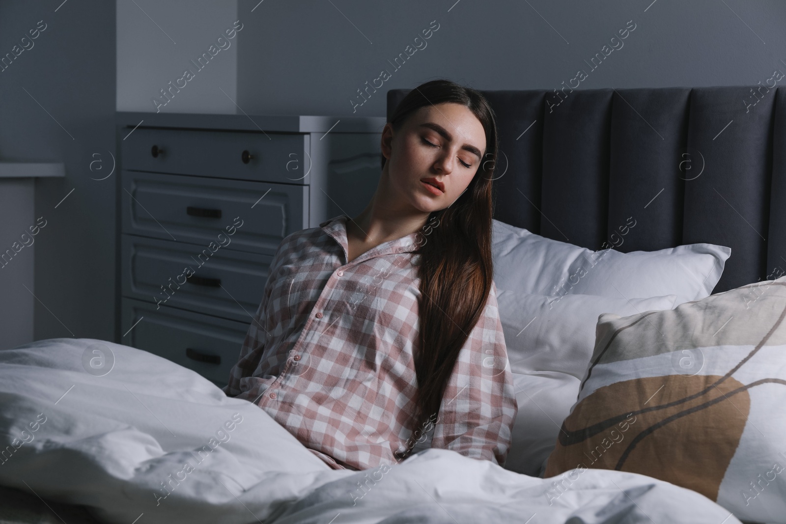 Photo of Young woman suffering from sleepwalking on bed at home