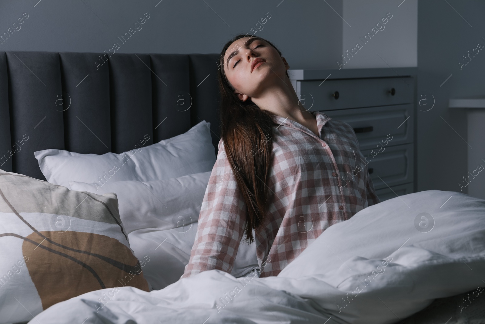 Photo of Young woman suffering from sleepwalking on bed at home