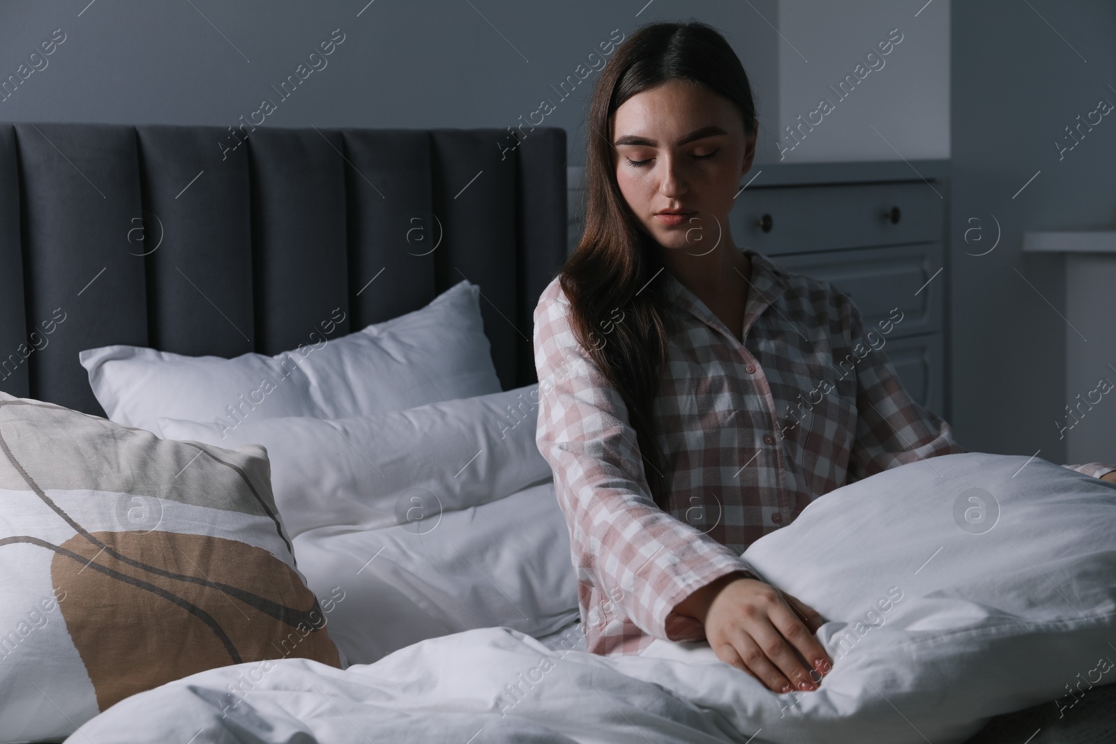 Photo of Young woman suffering from sleepwalking on bed at home