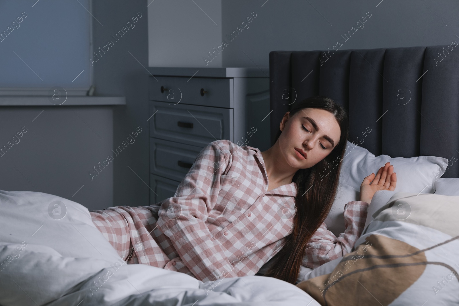 Photo of Young woman suffering from sleepwalking on bed at home