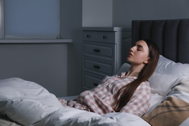 Photo of Young woman suffering from sleepwalking on bed at home