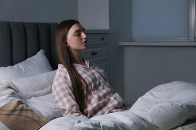 Photo of Young woman suffering from sleepwalking on bed at home