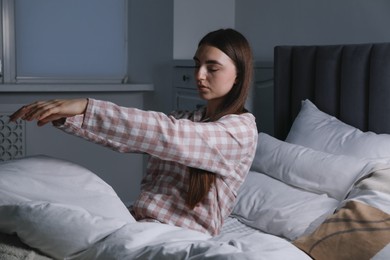 Photo of Young woman suffering from sleepwalking on bed at home