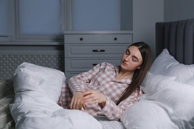 Photo of Young woman suffering from sleepwalking on bed at home