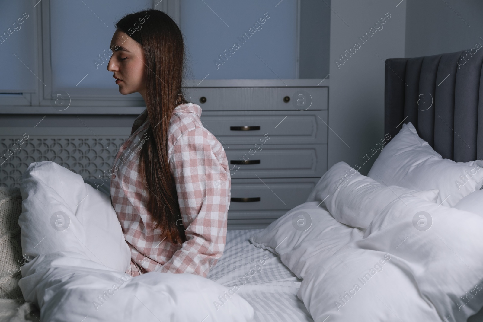 Photo of Young woman suffering from sleepwalking on bed at home