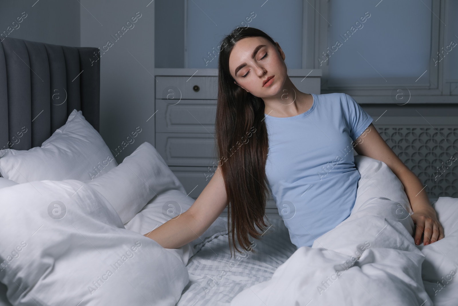 Photo of Young woman suffering from sleepwalking on bed at home