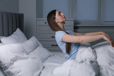 Photo of Young woman suffering from sleepwalking on bed at home