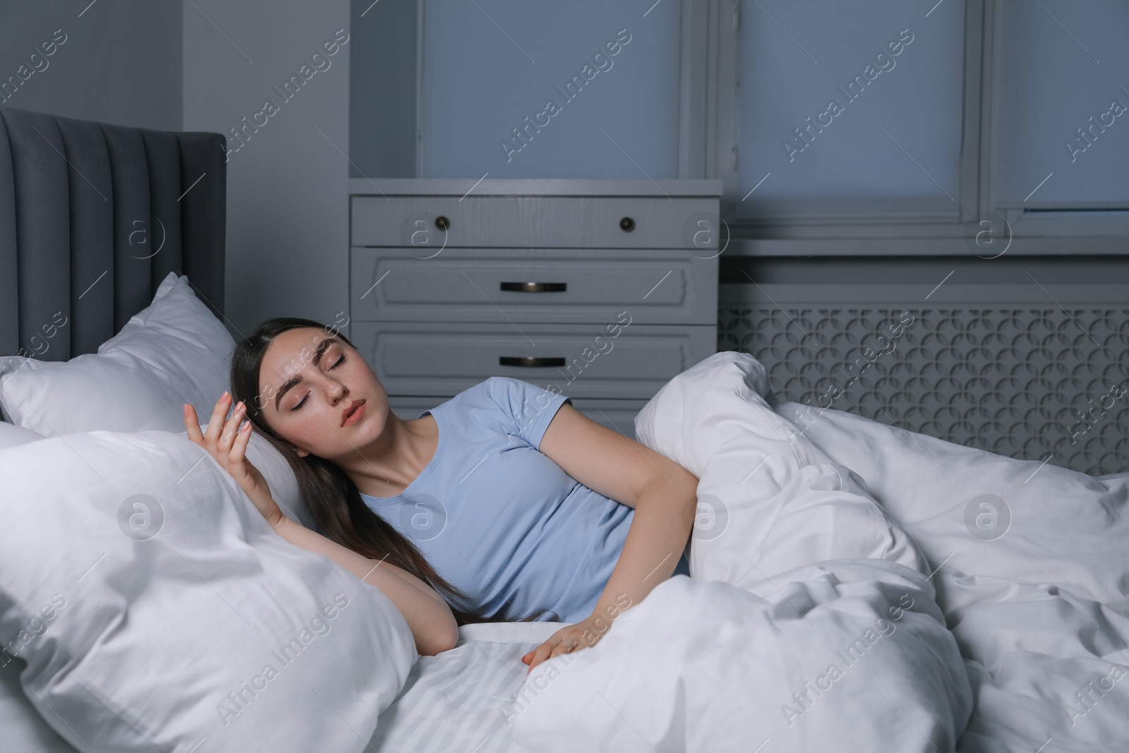 Photo of Young woman suffering from sleepwalking on bed at home