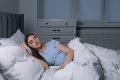 Photo of Young woman suffering from sleepwalking on bed at home