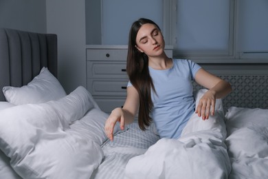 Photo of Young woman suffering from sleepwalking on bed at home