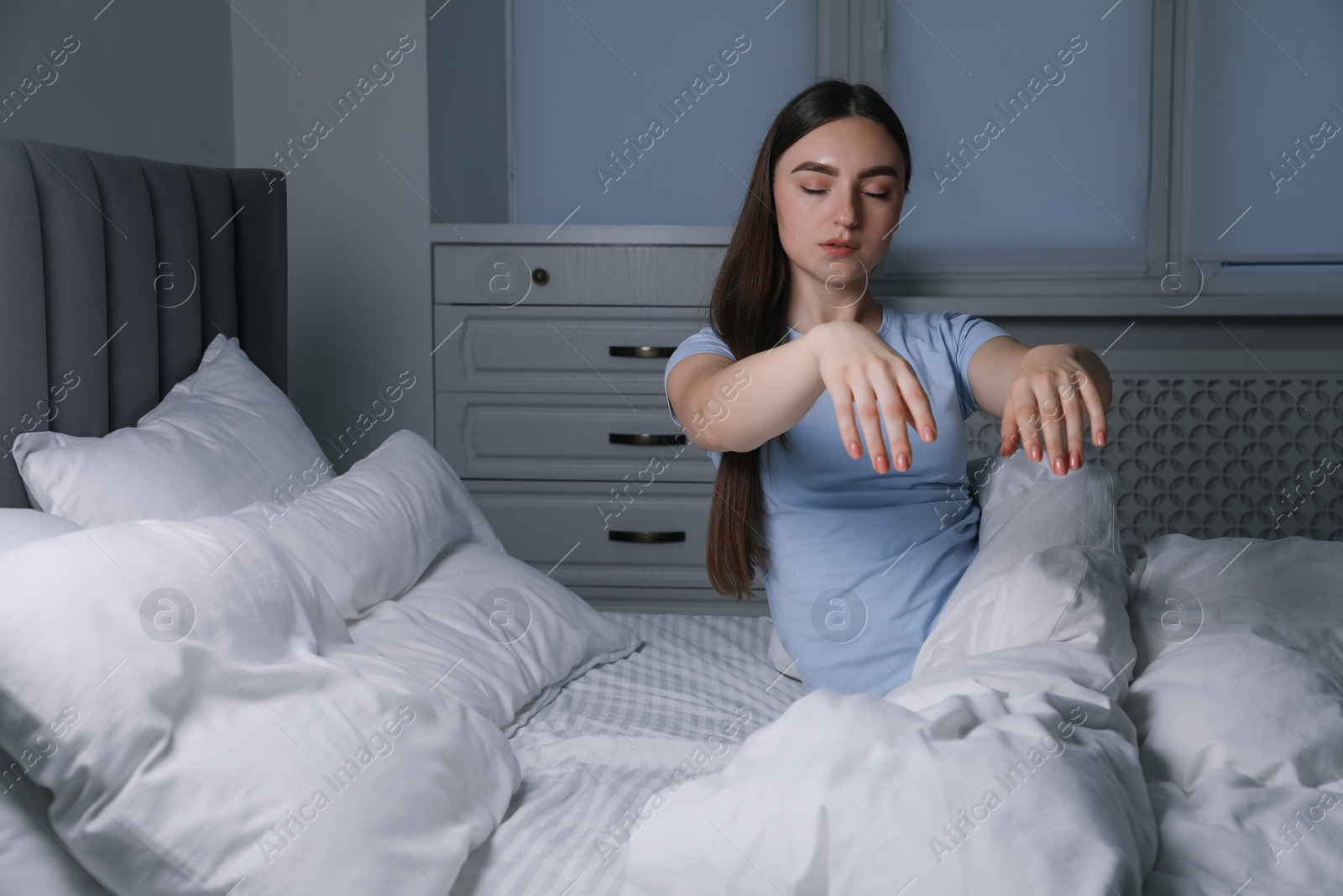 Photo of Young woman suffering from sleepwalking on bed at home