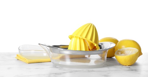 Photo of Juicer and fresh lemons on marble table against white background