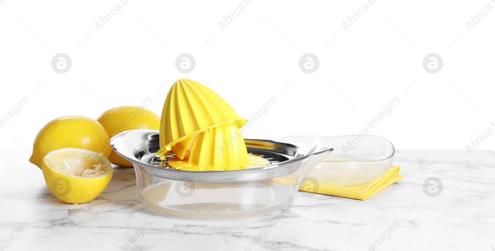 Photo of Juicer and fresh lemons on marble table against white background