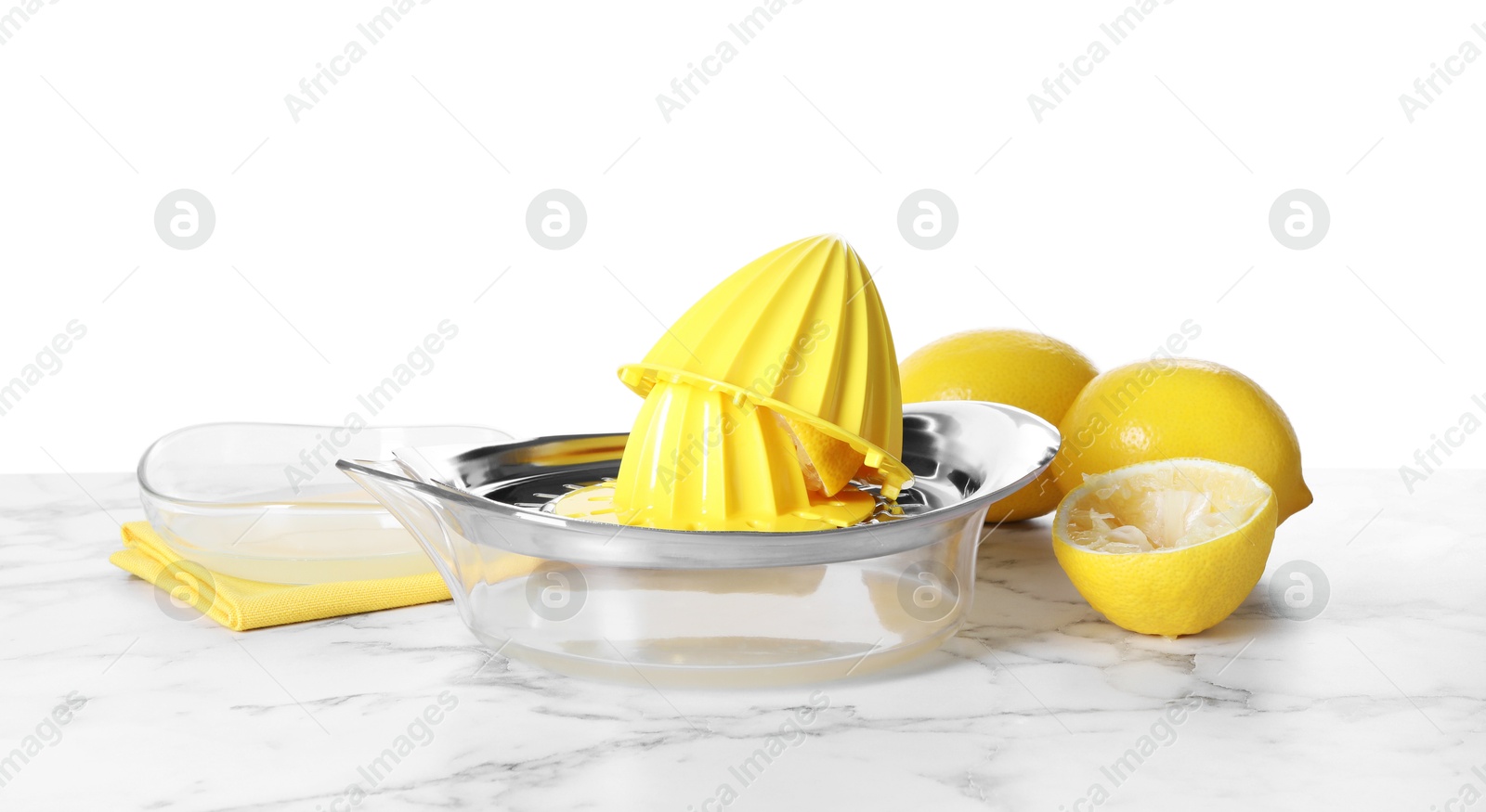 Photo of Juicer and fresh lemons on marble table against white background