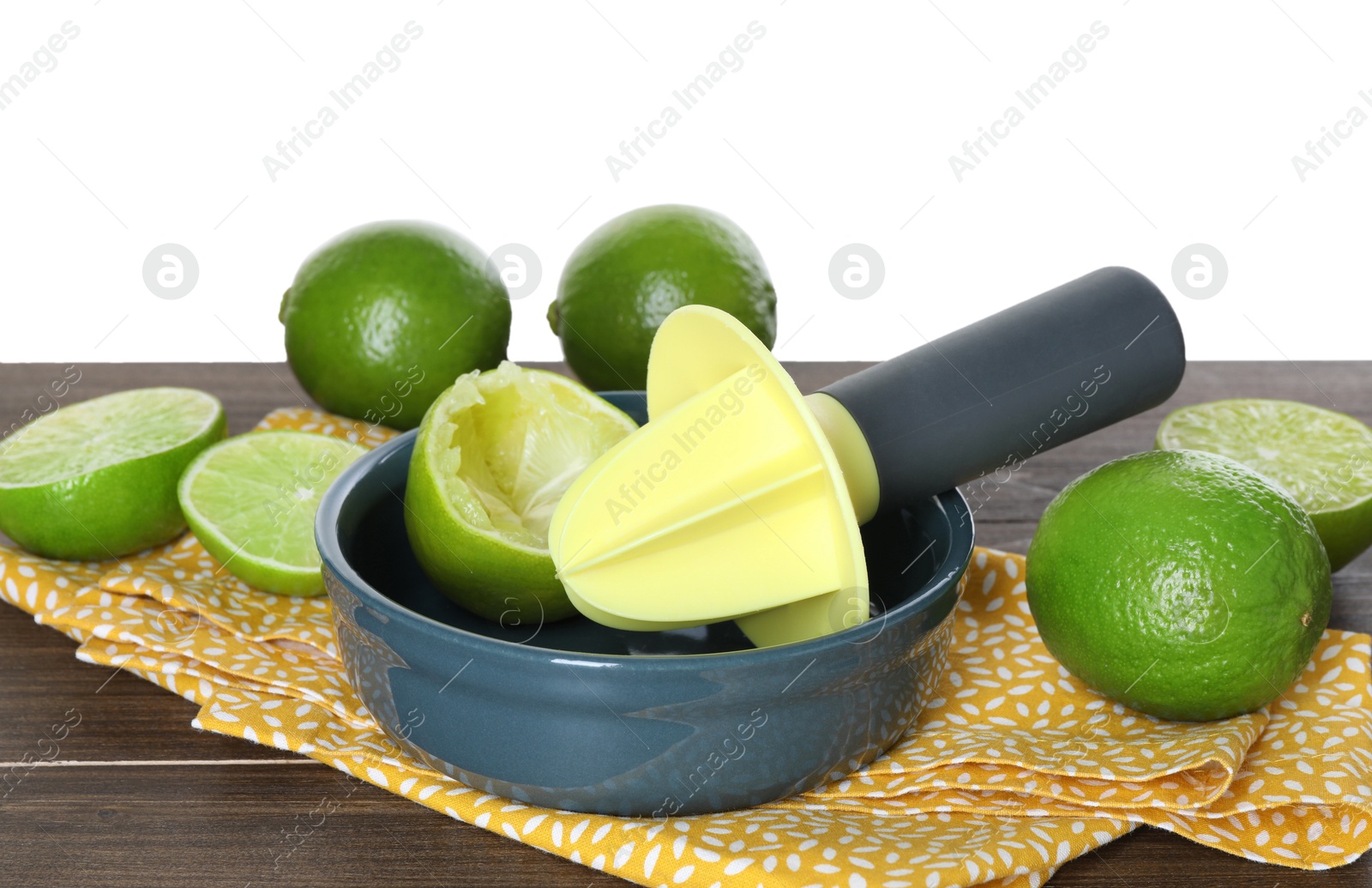 Photo of Plastic juicer and fresh limes on wooden table against white background