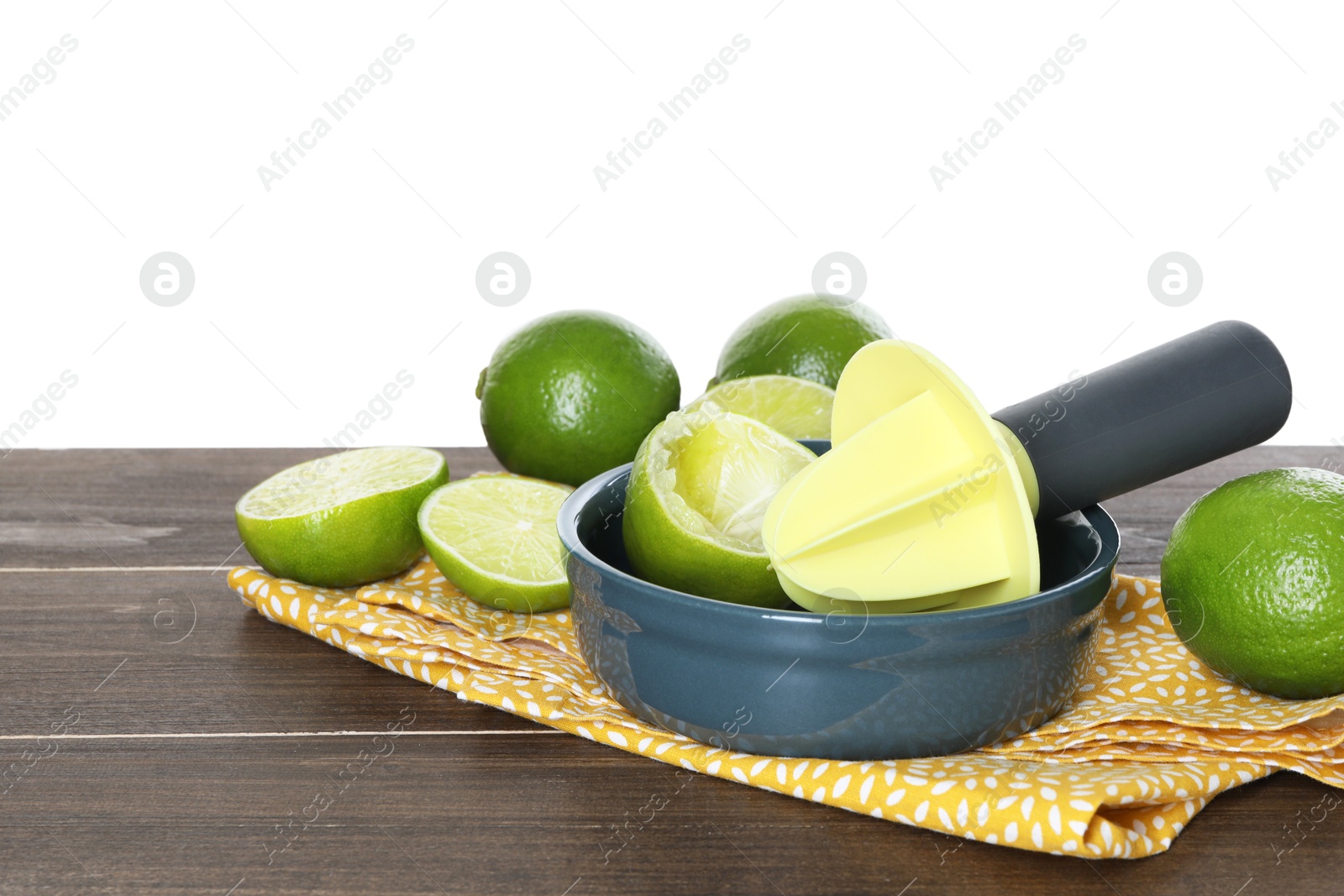 Photo of Plastic juicer and fresh limes on wooden table against white background