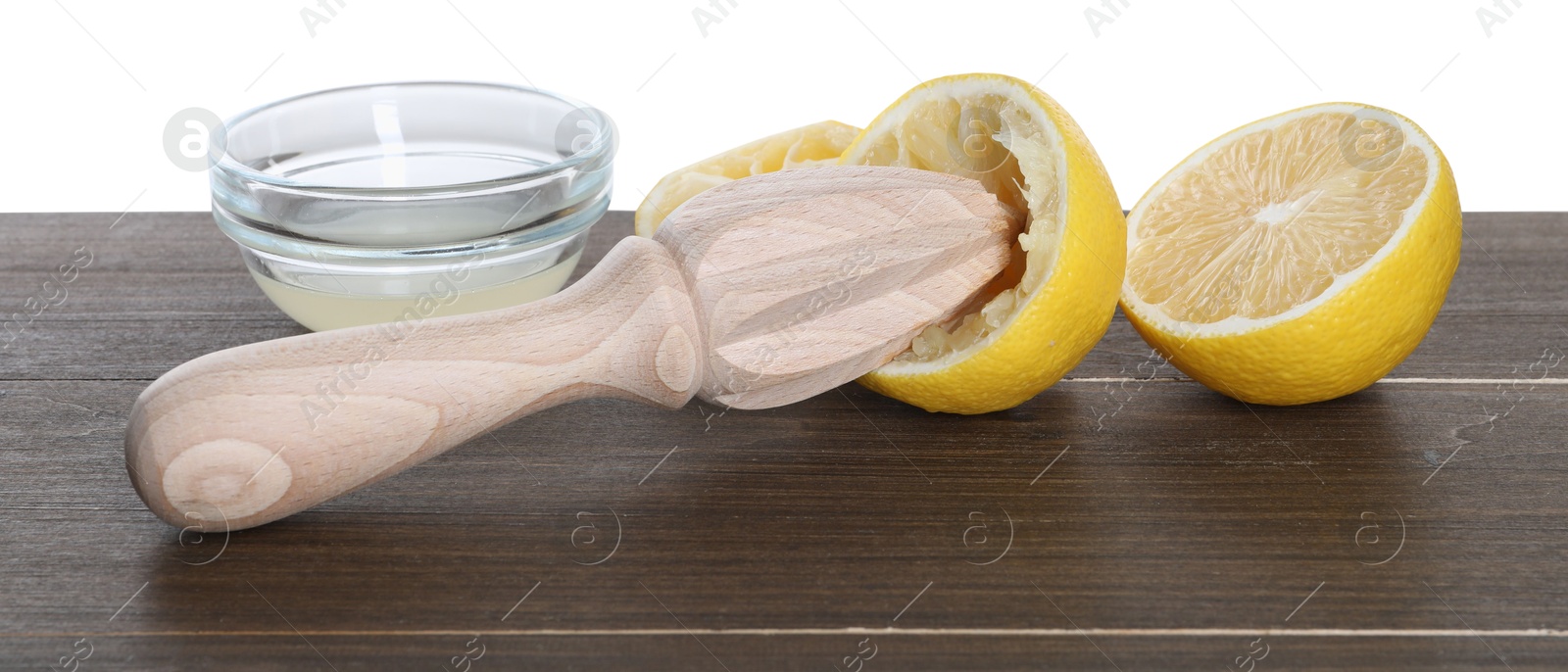 Photo of Juicer and fresh lemons on wooden table against white background