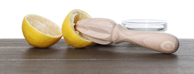 Photo of Juicer and fresh lemons on wooden table against white background