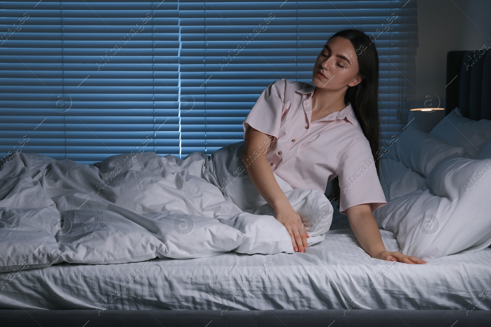 Photo of Young woman suffering from sleepwalking on bed at home