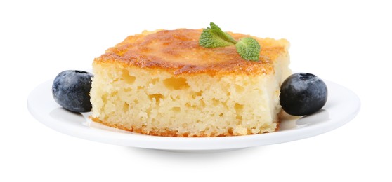 Photo of Slice of tasty semolina cake and blueberries isolated on white