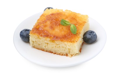 Photo of Slice of tasty semolina cake and blueberries isolated on white