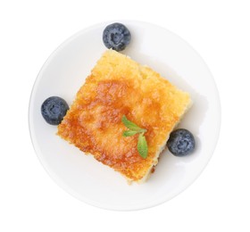 Photo of Slice of tasty semolina cake and blueberries isolated on white, top view