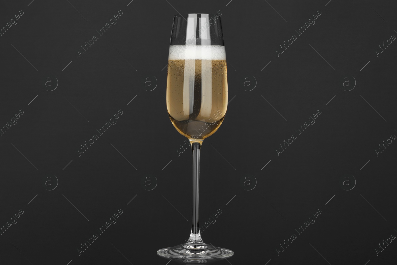 Photo of Champagne in glass on grey background. Sparkling wine