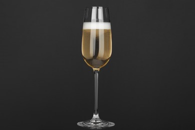 Photo of Champagne in glass on grey background. Sparkling wine