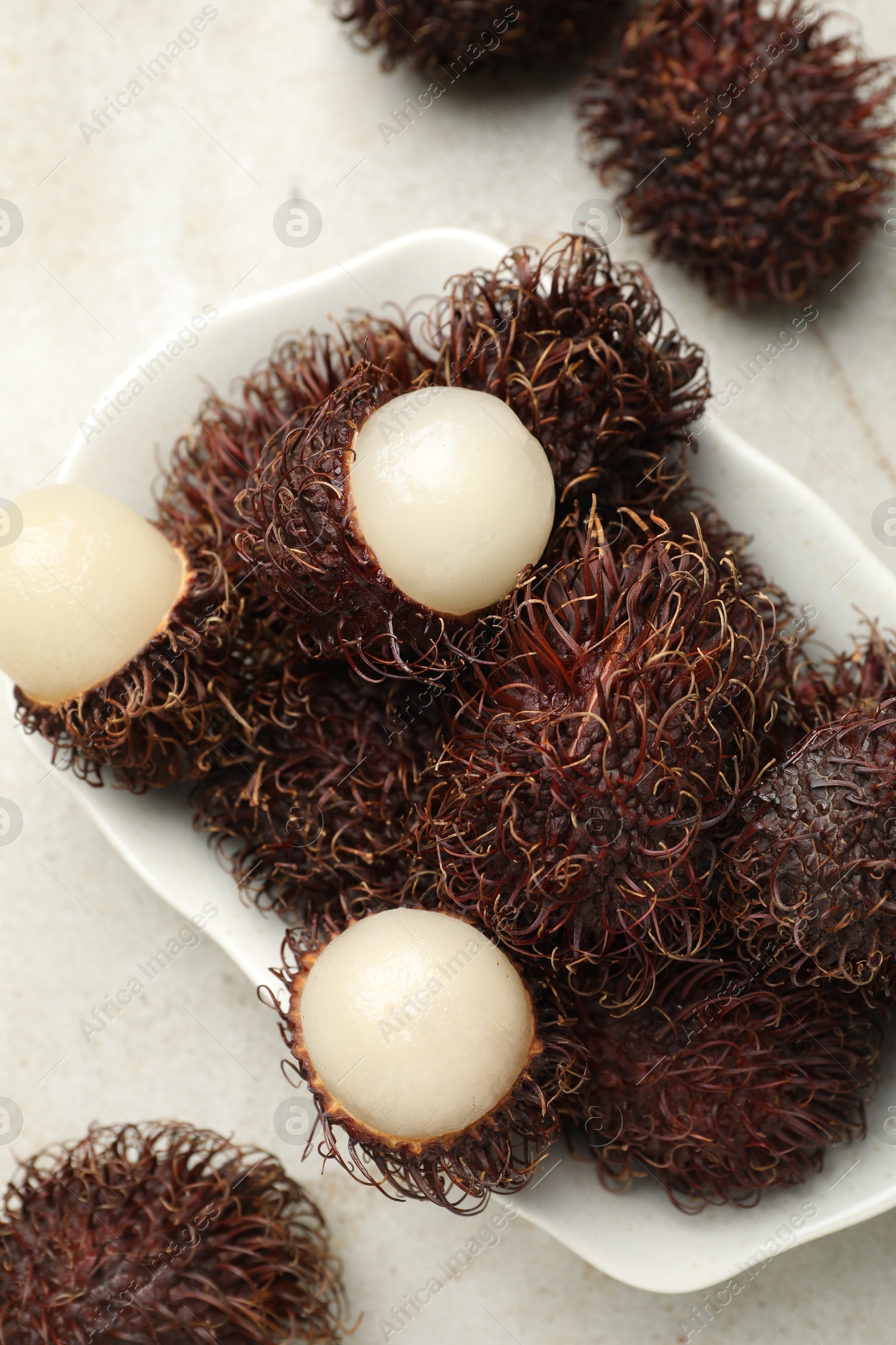 Photo of Delicious ripe rambutans on light grey table, top view