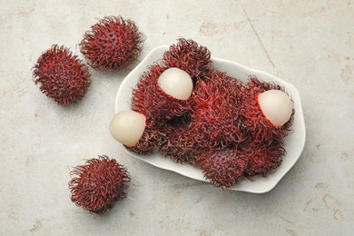 Photo of Delicious ripe rambutans on light grey table, top view