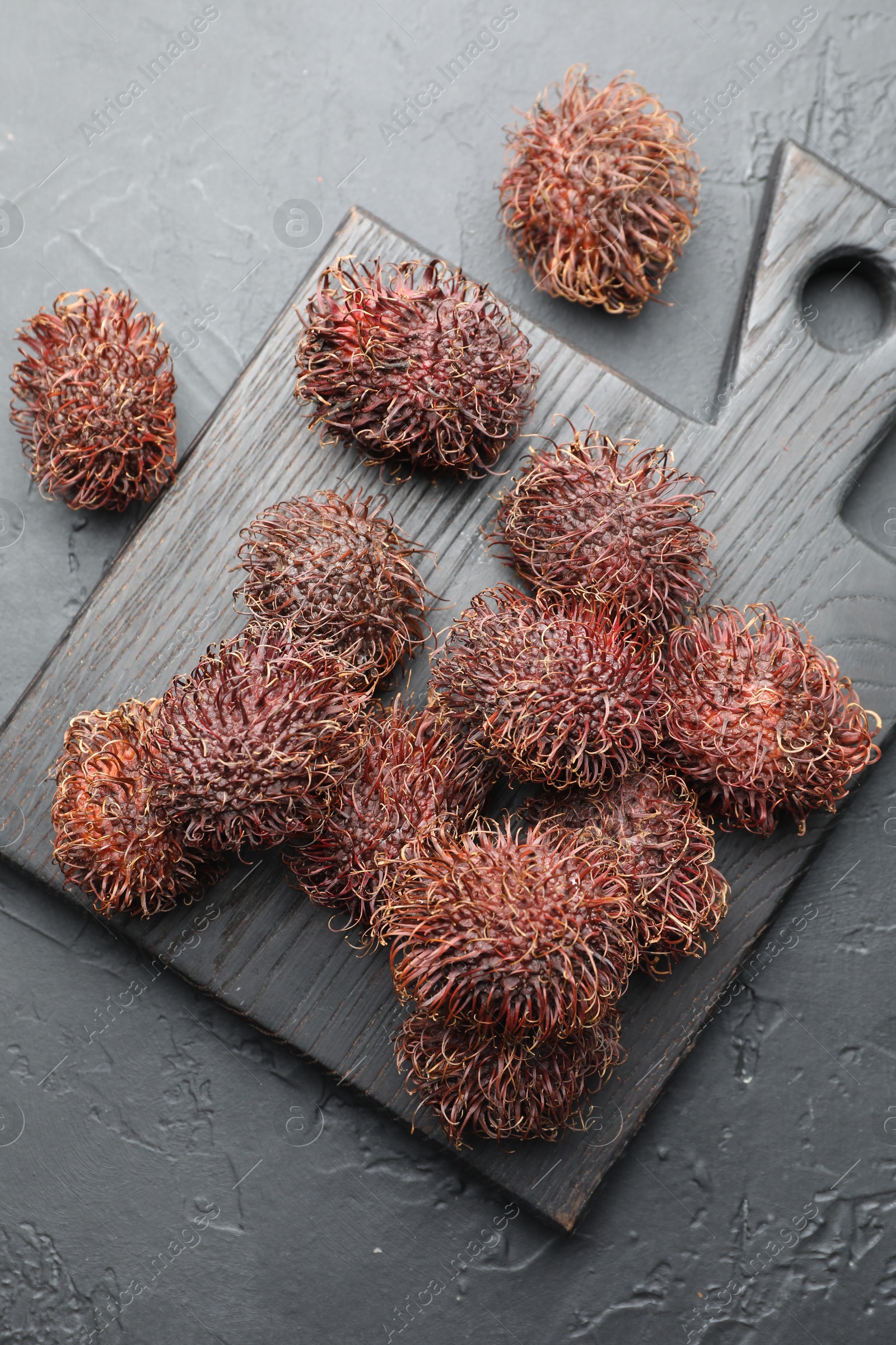 Photo of Delicious ripe rambutans on black table, top view