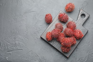 Photo of Delicious ripe rambutans on black table, top view. Space for text