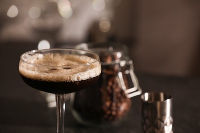 Photo of Delicious espresso martini in glass on blurred background, closeup. Space for text