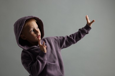 Photo of Portrait of scared little boy on grey background