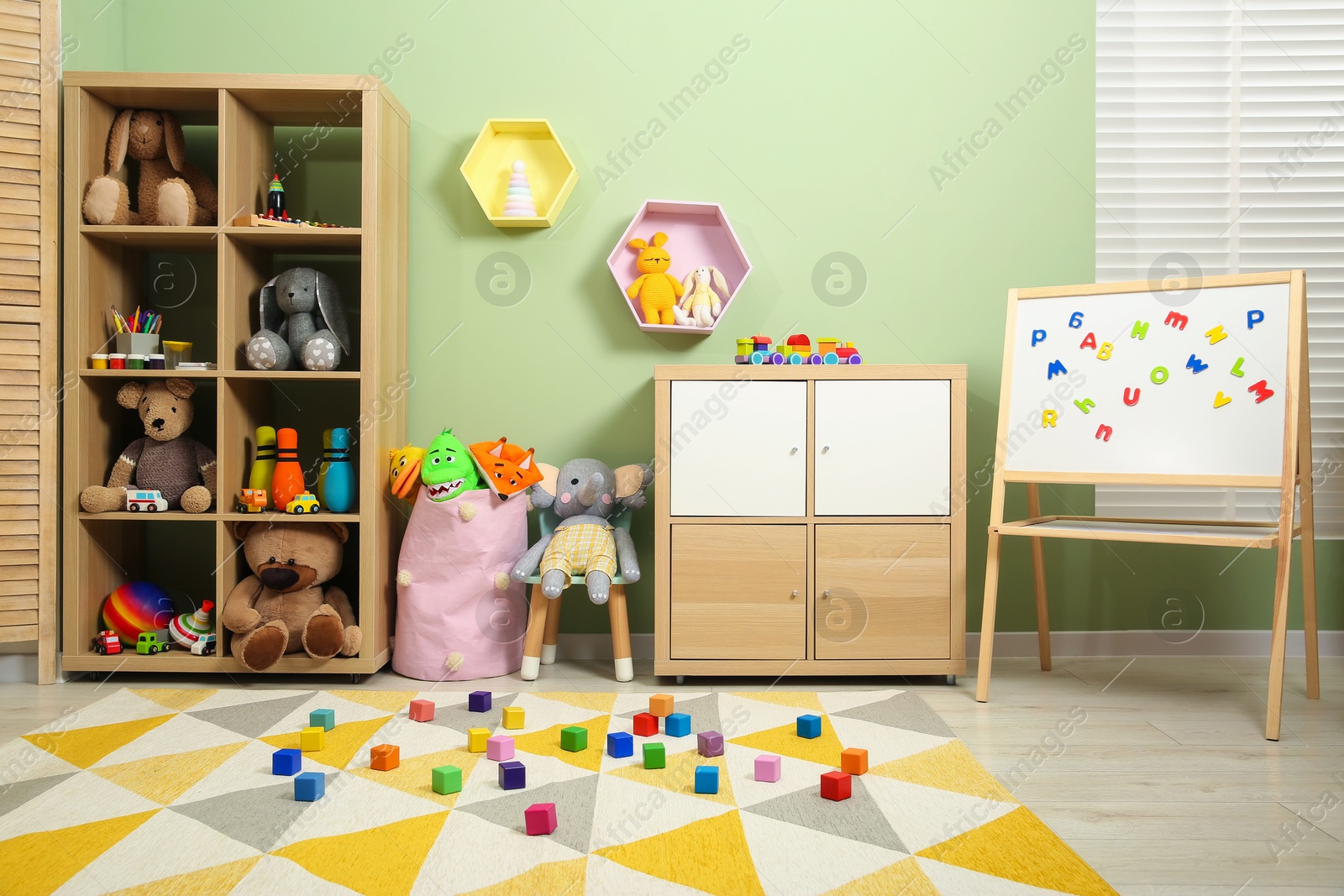 Photo of Colorful cubes on carpet and different toys in child's room