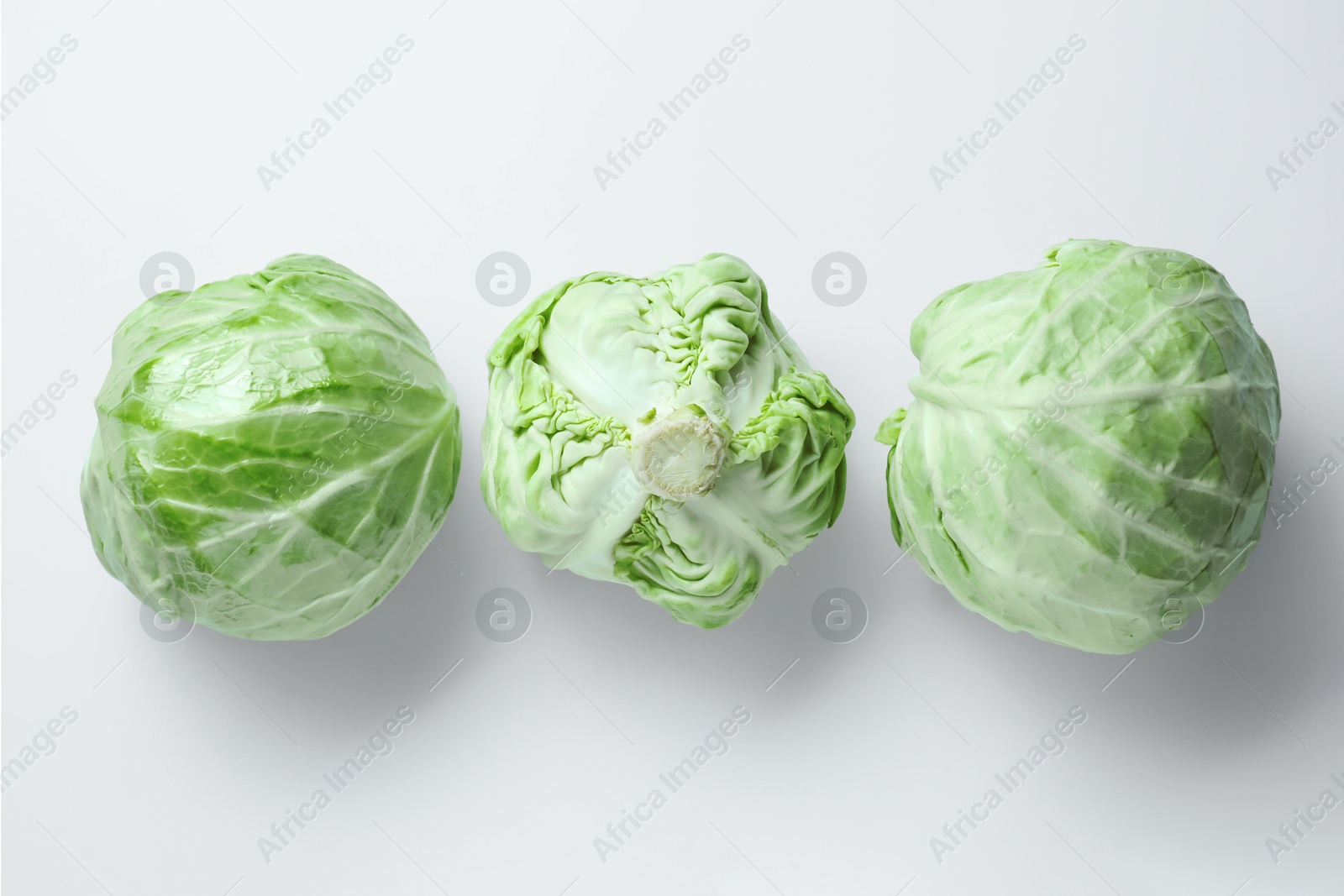 Photo of Raw green cabbages on white background, flat lay