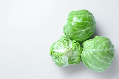 Photo of Raw green cabbages on white background, flat lay. Space for text