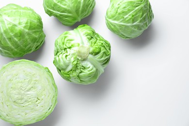 Photo of Raw green cabbages on white background, flat lay. Space for text