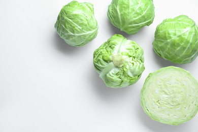 Photo of Raw green cabbages on white background, flat lay. Space for text