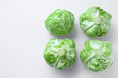 Photo of Raw green cabbages on white background, flat lay. Space for text