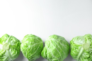 Photo of Raw green cabbages on white background, flat lay. Space for text